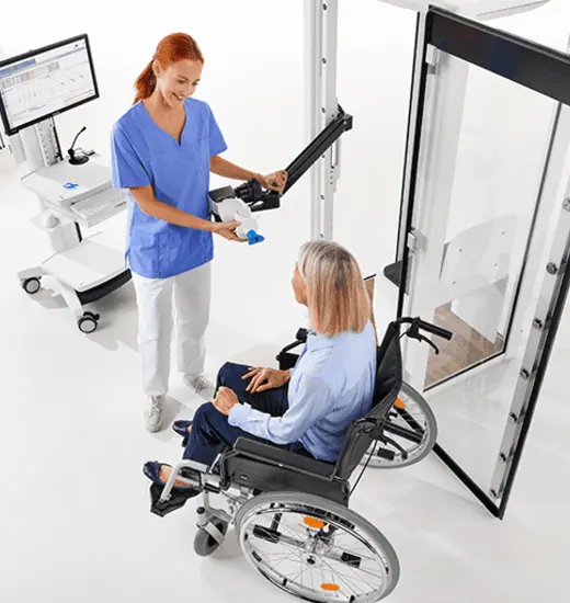 Clinician using the remote arm to test a patient in a wheelchair with Vyaire's Vyntus™ BODY Plethysmograph.