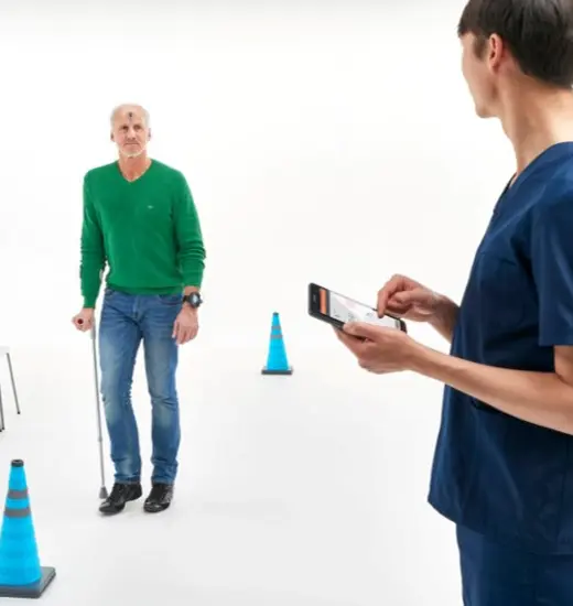 A clinician observing a patient walking with the test device on.