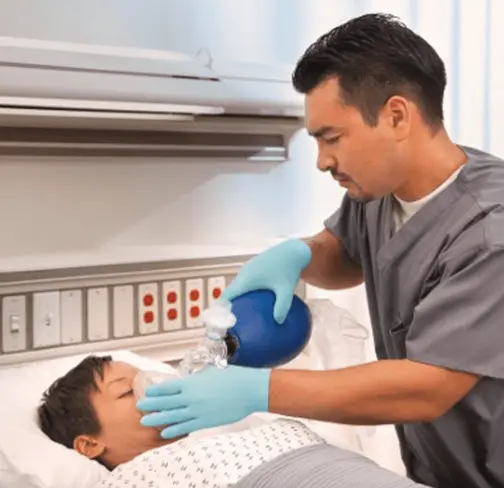 Clinician using a Vyaire self-inflating resuscitation device on a pediatric patient.